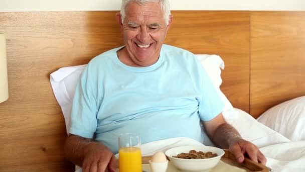 Старший мужчина завтракает в постели — стоковое видео