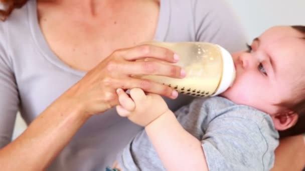 Moeder voeden haar babyjongen zijn fles — Stockvideo