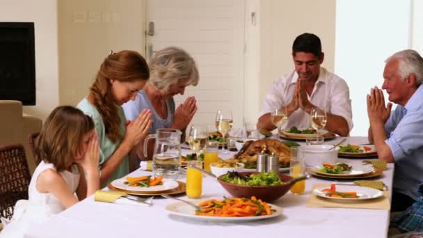 Família estendida dizendo graça juntos antes do jantar — Vídeo de Stock