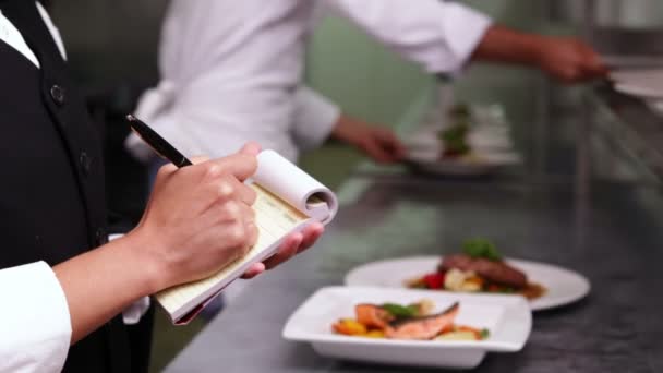 Smiling waitress writing on her notepad — Stock Video