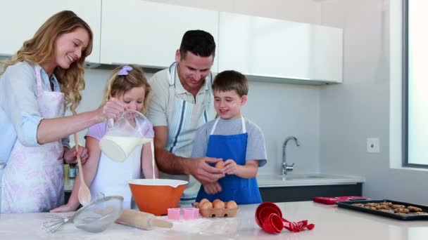 Felice giovane famiglia facendo una torta insieme — Video Stock