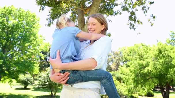 Feliz madre sosteniendo a su niña en el parque — Vídeos de Stock