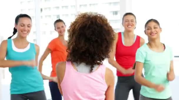 Pretty instructor leading zumba class in fitness studio — Stock Video