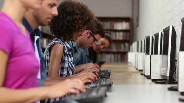 Estudiantes sentados en fila trabajando en computadoras — Vídeo de stock