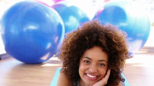 Mujer sonriente acostada en una alfombra de ejercicio — Vídeos de Stock