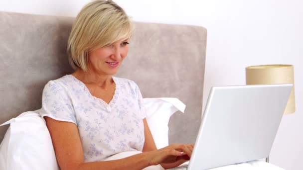 Mulher feliz usando laptop na cama — Vídeo de Stock