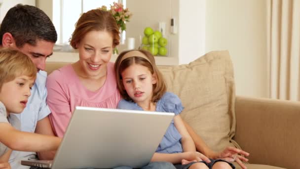 Família sentada no sofá usando laptop juntos — Vídeo de Stock