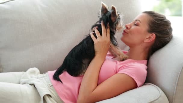 Vacker kvinna leker med yorkshire terrier valp på soffan — Stockvideo