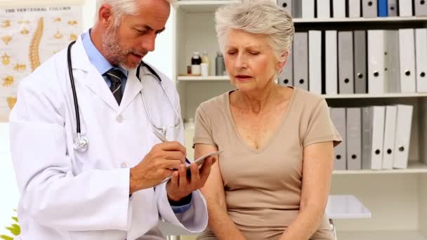 Doctor explaining a prescription to his patient — Stock Video