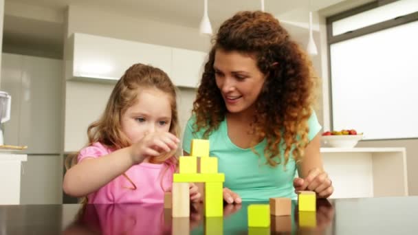 Mor och dotter leker med byggstenar vid bordet — Stockvideo