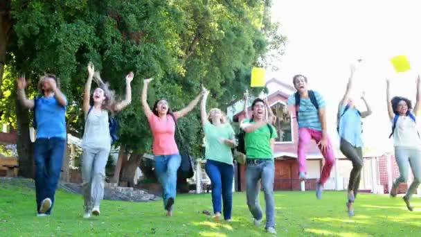 Celebrando a los estudiantes corriendo y tirando libros juntos — Vídeo de stock