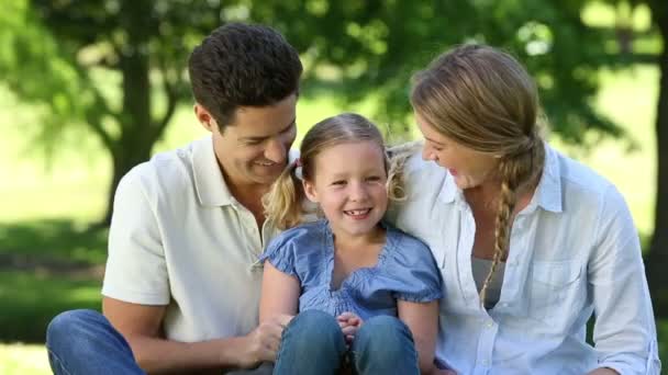 Gelukkige ouders met hun jonge dochter in het park — Stockvideo