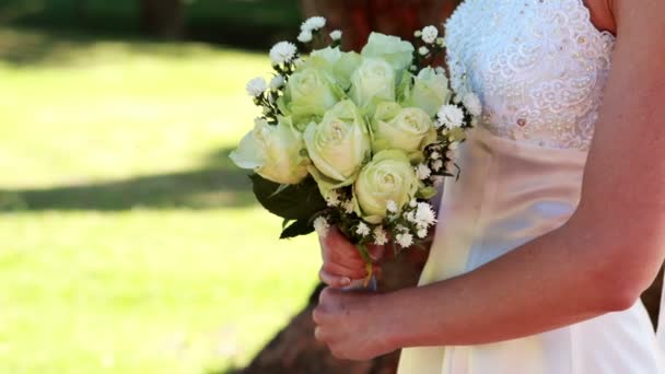 Novia sosteniendo un ramo en el parque — Vídeos de Stock