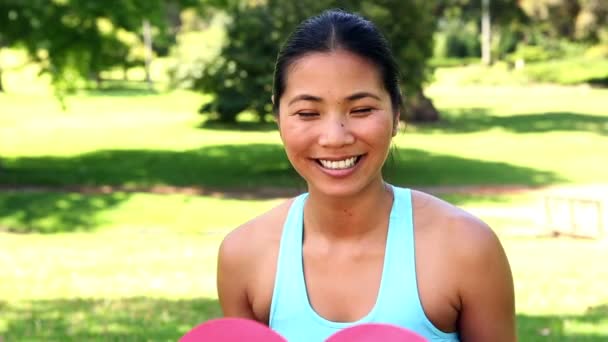 Fit азиатская девушка показывает бумажное сердце — стоковое видео