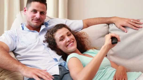 Par avkopplande på soffan tittar på tv — Stockvideo