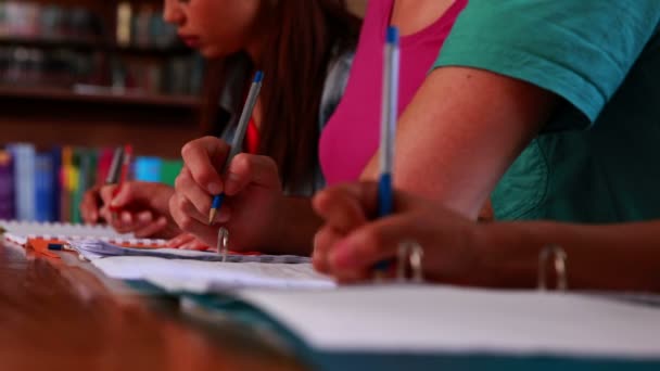 Studenten schrijven in de bibliotheek — Stockvideo