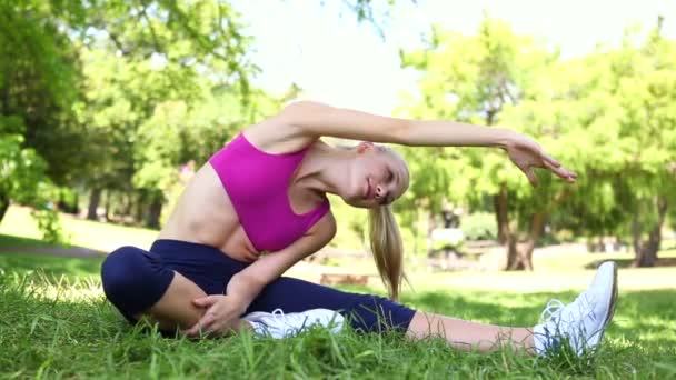 Passa blond stretching på gräset — Stockvideo