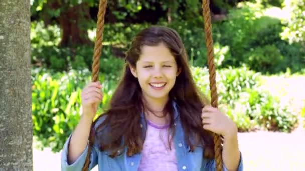 Girl sitting on a swing in the park — Stock Video