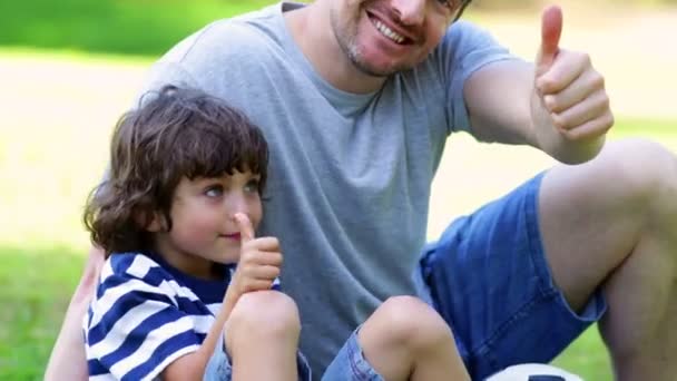 Otec sedí s malým synem ukazuje palec — Stock video