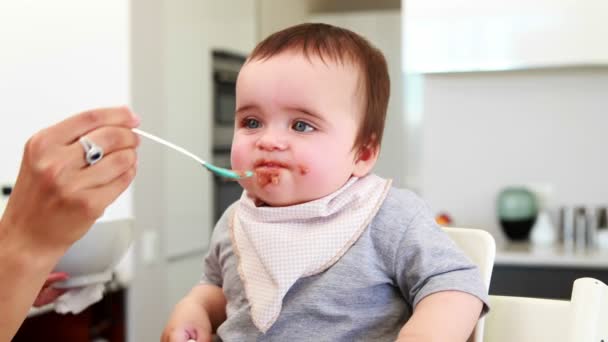 Unordentliches Baby, das gefüttert wird — Stockvideo