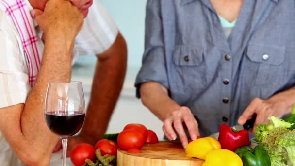 Coppia anziana che prepara un pasto sano mentre beve vino rosso — Video Stock