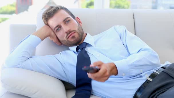 Businessman sitting on couch watching tv — Stock Video