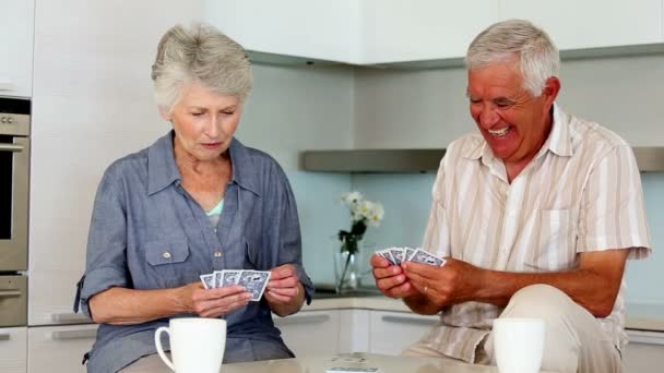 Couple senior jouant aux cartes au comptoir — Video