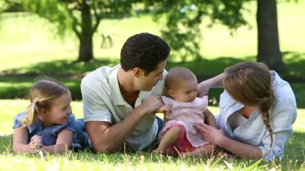 Padres con su familia joven en el parque — Vídeos de Stock