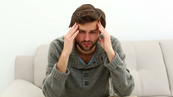 Young depressed man sitting on sofa — Stock Video