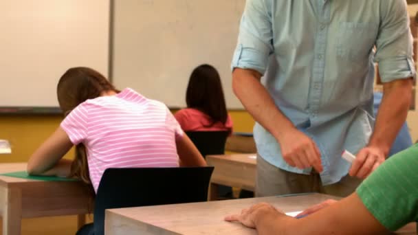 Enseignant aidant un élève en classe — Video