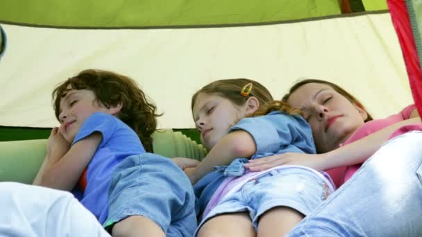 Familia tomando una siesta en su tienda de campaña en un viaje de campamento — Vídeo de stock