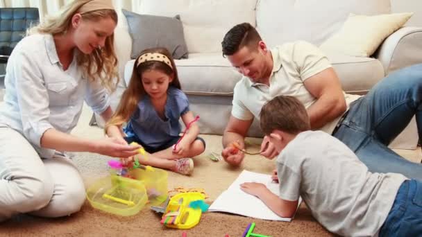 Hermanos haciendo artes y manualidades en la alfombra con los padres — Vídeos de Stock