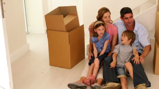 Familie zittend op de vloer in hun nieuwe huis — Stockvideo