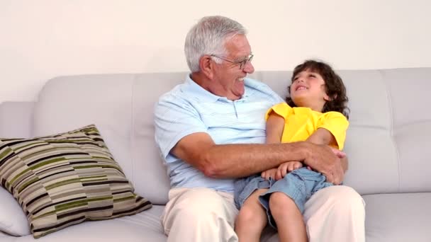 Senior man sitting on couch with his grandson — Stock Video