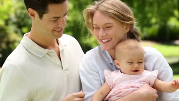 Gelukkige ouders met hun babymeisje in het park — Stockvideo