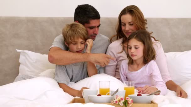 Χαριτωμένο γονείς και παιδιά κατοχής του προγεύματος στο κρεβάτι — Αρχείο Βίντεο