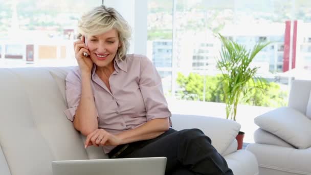 Businesswoman talking on phone and using laptop — Stock Video