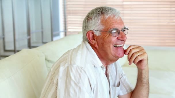 Homem idoso feliz sentado no sofá — Vídeo de Stock