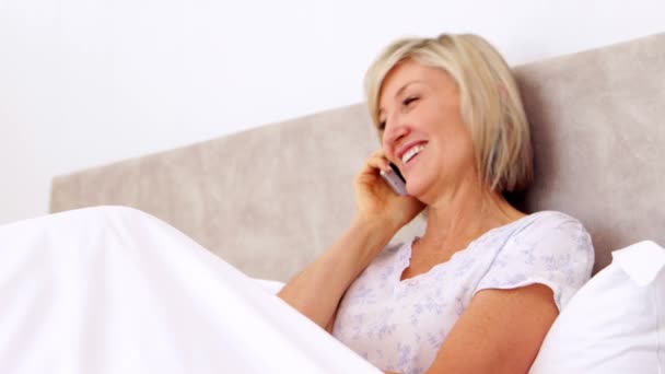 Happy woman talking on phone in bed — Stock Video