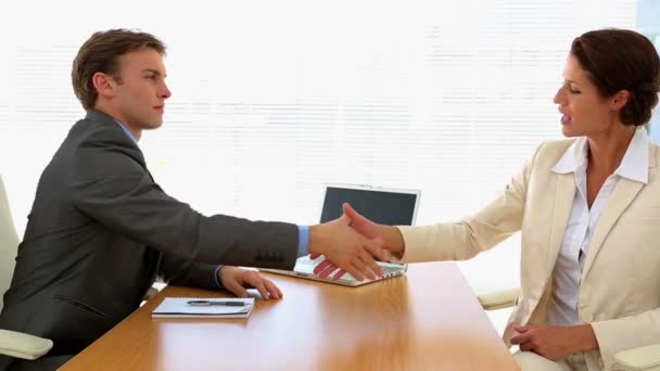 Business people shaking hands at desk — Stock Video