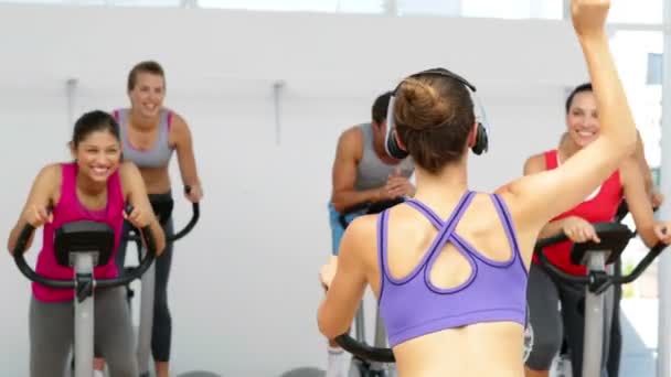 Spinning klass i fitnesstudion leds av energisk instruktör — Stockvideo