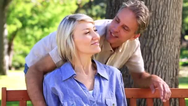 Homem feliz abraçando seu parceiro no banco do parque — Vídeo de Stock