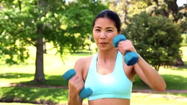 Fit asian girl lifting dumbbells — Stock Video