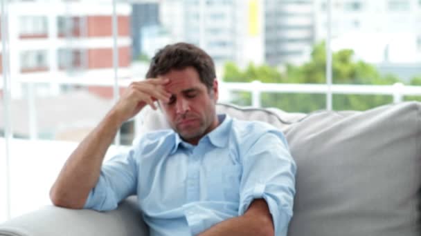 Stressed man sitting on the sofa — Stock Video