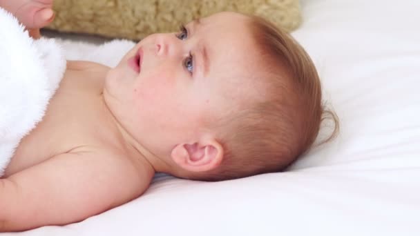 Schattige baby liggend op een bed — Stockvideo