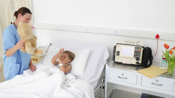 Enfermera tratando de animar a una niña enferma — Vídeos de Stock