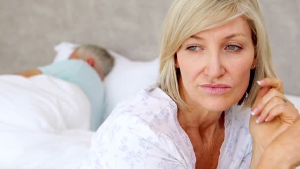 Unhappy woman thinking while her husband is sleeping — Stock Video