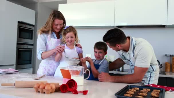 Lachende familie maken een cake samen — Stockvideo