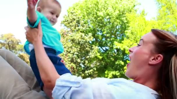 Madre jugando con su hijo pequeño en el parque — Vídeo de stock