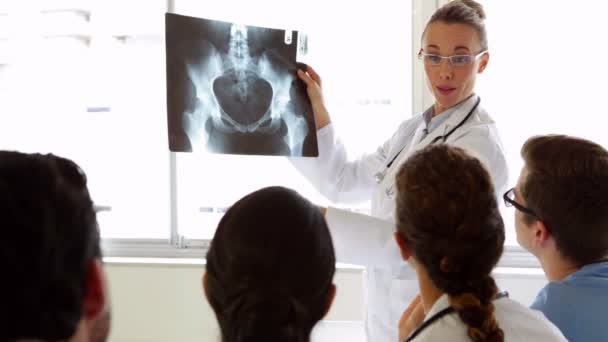 Medical team listening to doctor explain an xray — Stock Video